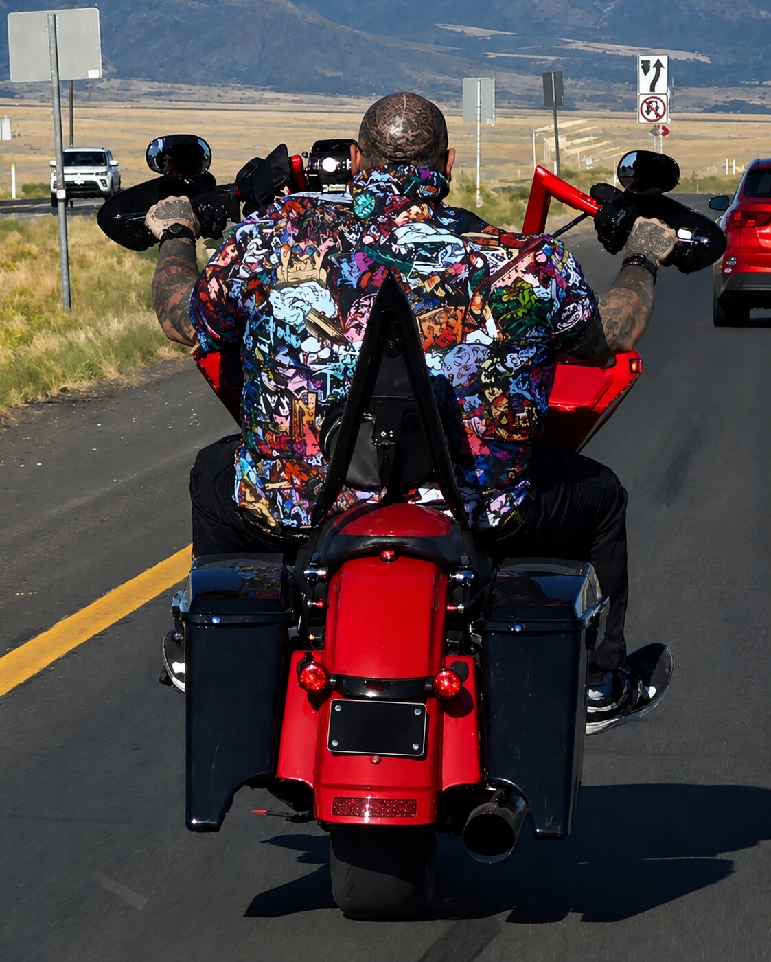 Junior riding his red motorcycle on an open road